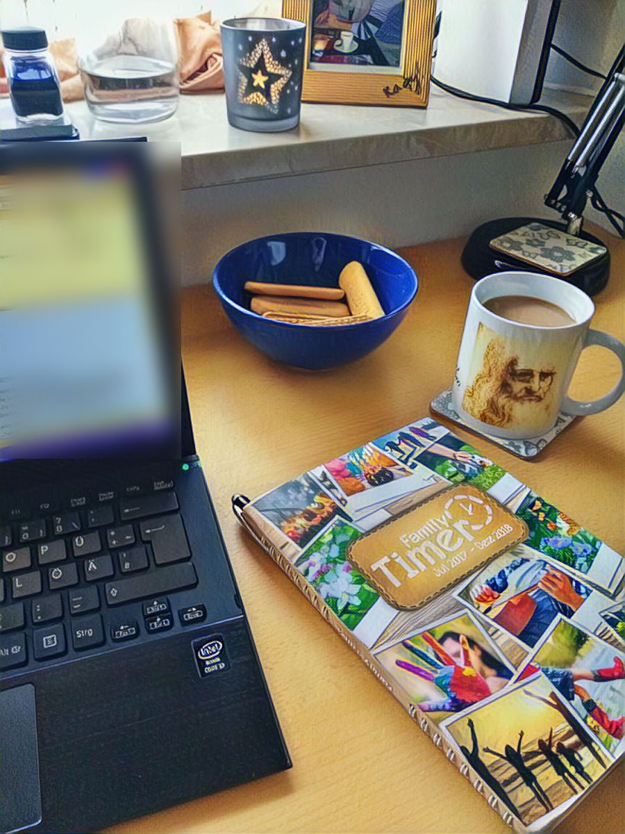 Schreibtisch mit Laptop, Kaffeetasse, Keksen und Planer
